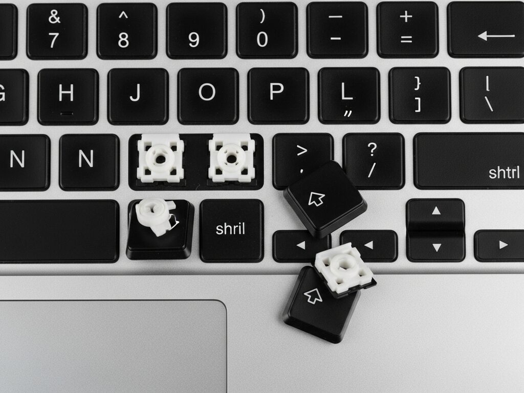 Laptop keyboard with three keys missing and the scissor mechanisms exposed