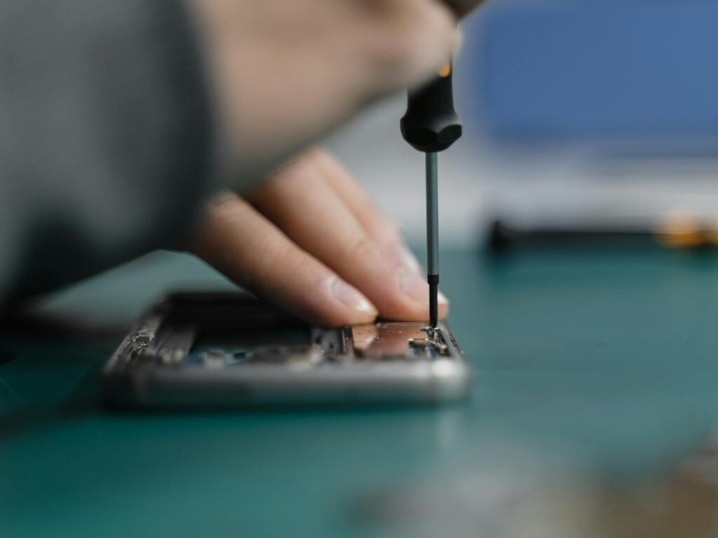 Technician using a precision screwdriver on an opened iPhone