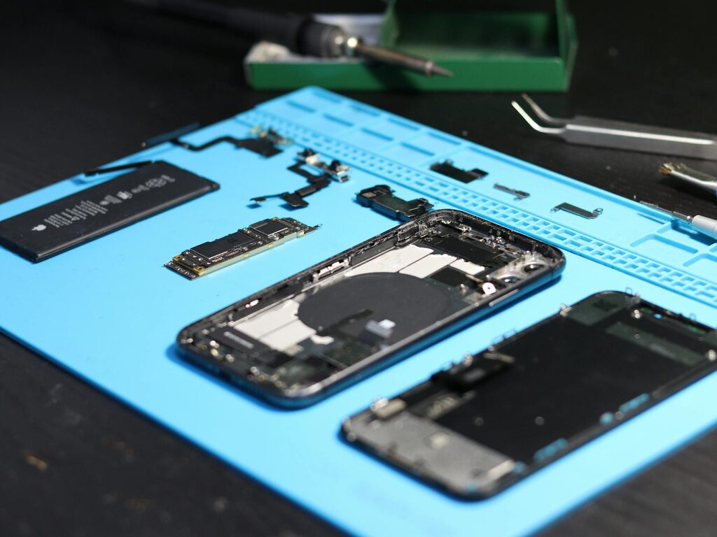 Pixel-style smartphone laid out with repair tools on a workbench