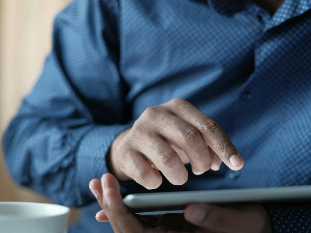 Hands holding a digital tablet up close